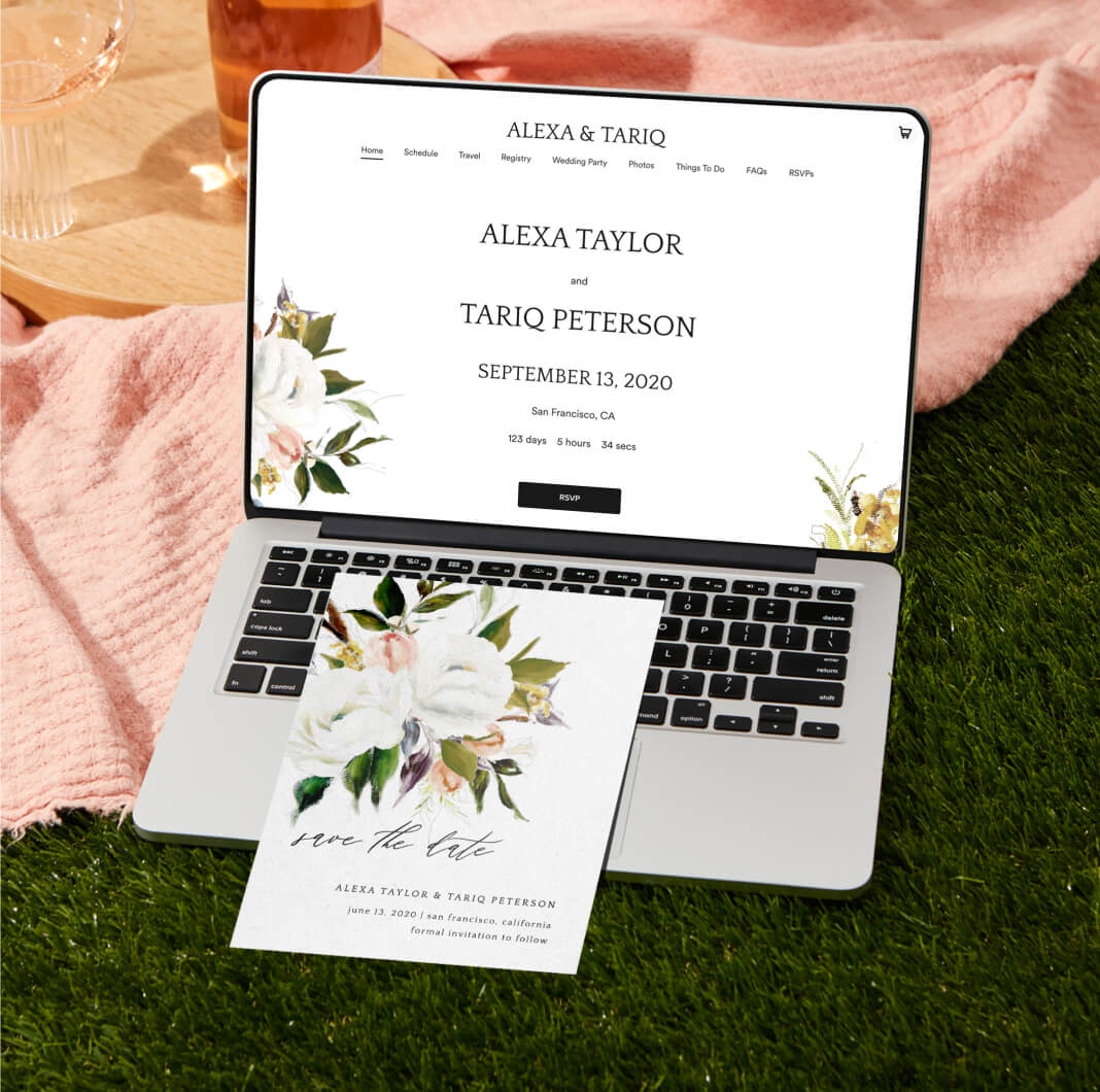 Save the date leaning on laptop showing wedding website with matching theme